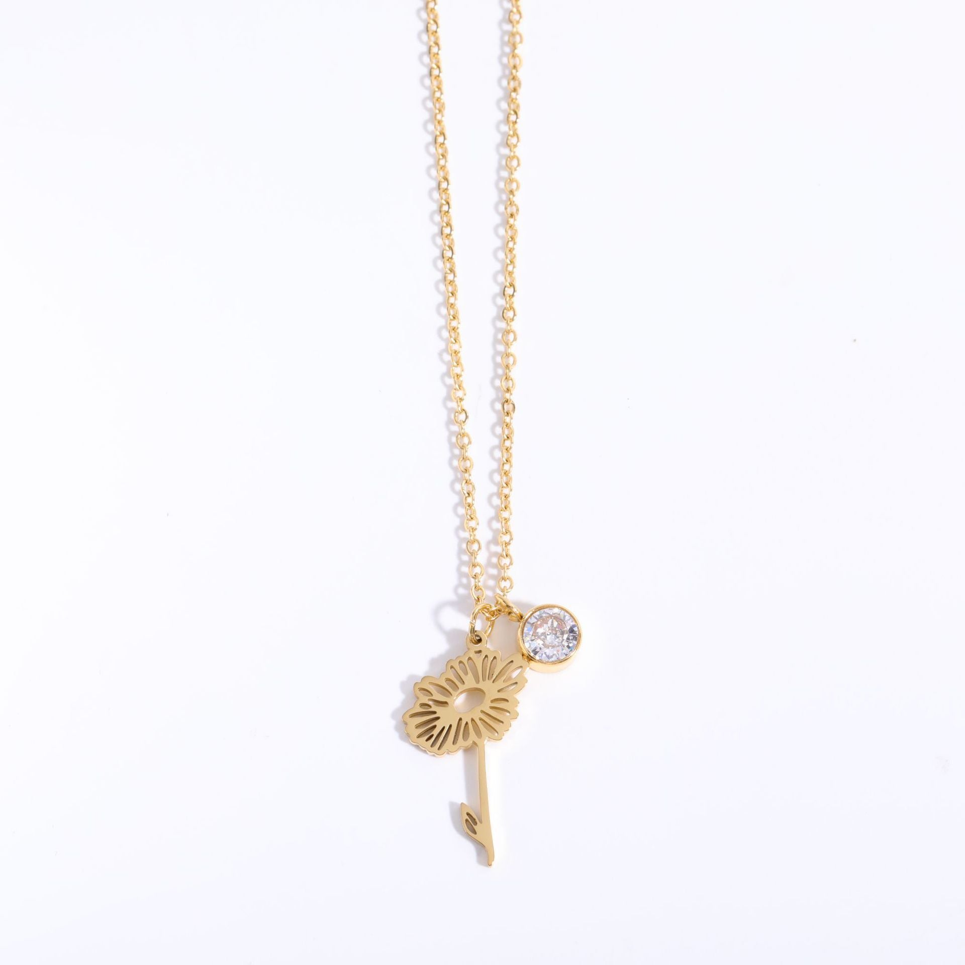 Gold necklace with a dandelion pendant on a white background