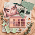 Makeup palette, brushes, and other items on a marble surface with decorative elements.