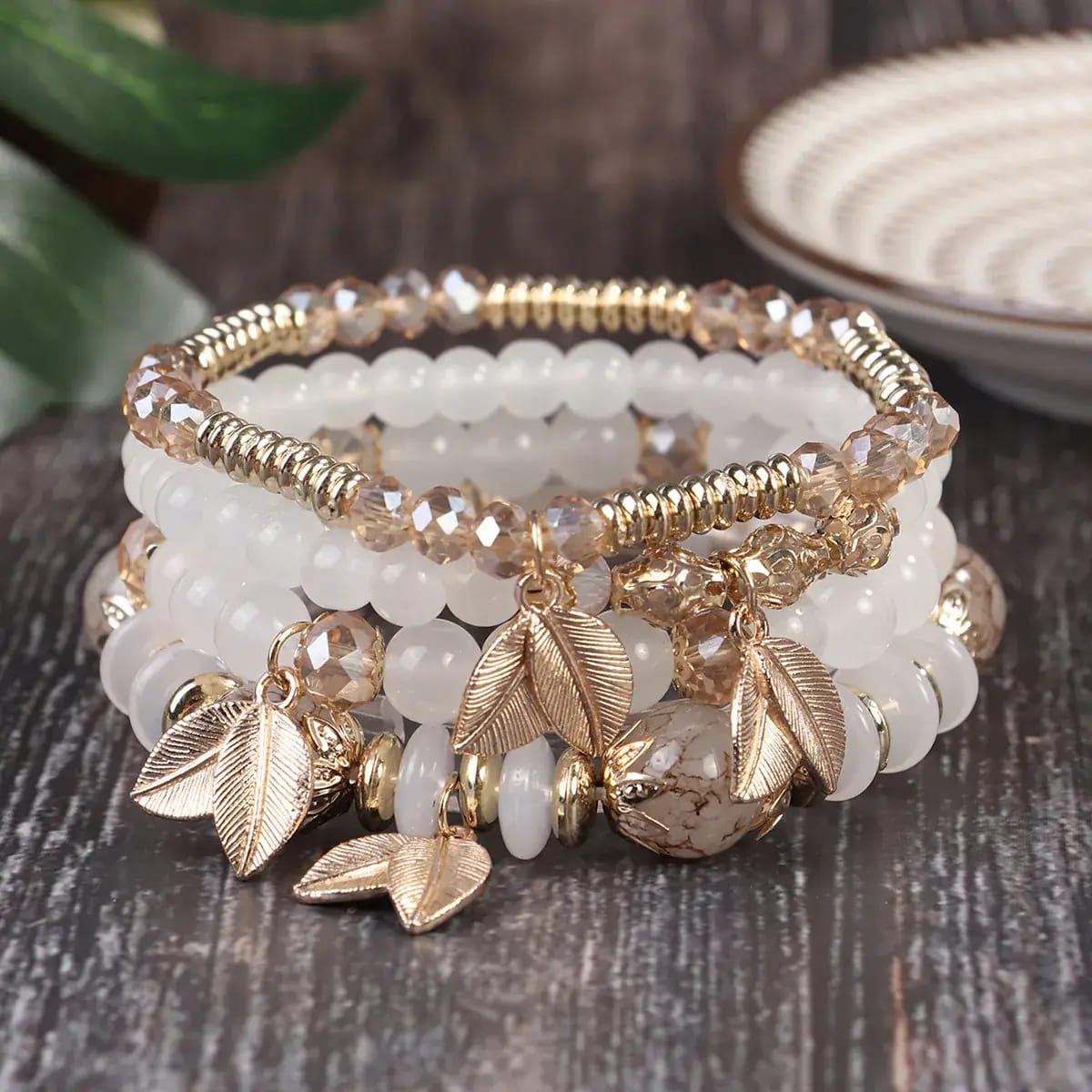 4-piece bohemian beaded bracelet stack with white resin beads and gold leaf charms