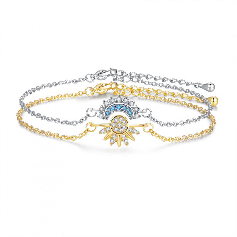 A set of three delicate double-strand chain bracelets, featuring one silver chain, one gold chain, and one mixed gold-and-silver chain, all adorned with a central Hamsa hand charm embellished with a blue crescent and clear stones.