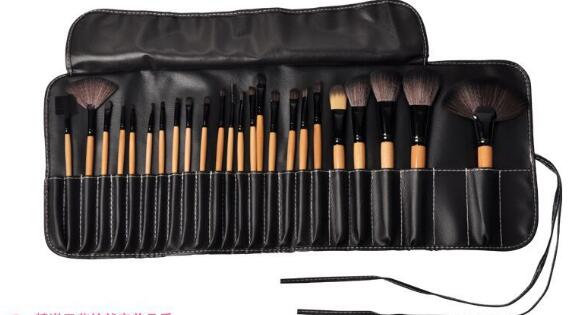 Set of makeup brushes in a black leather case on a white background