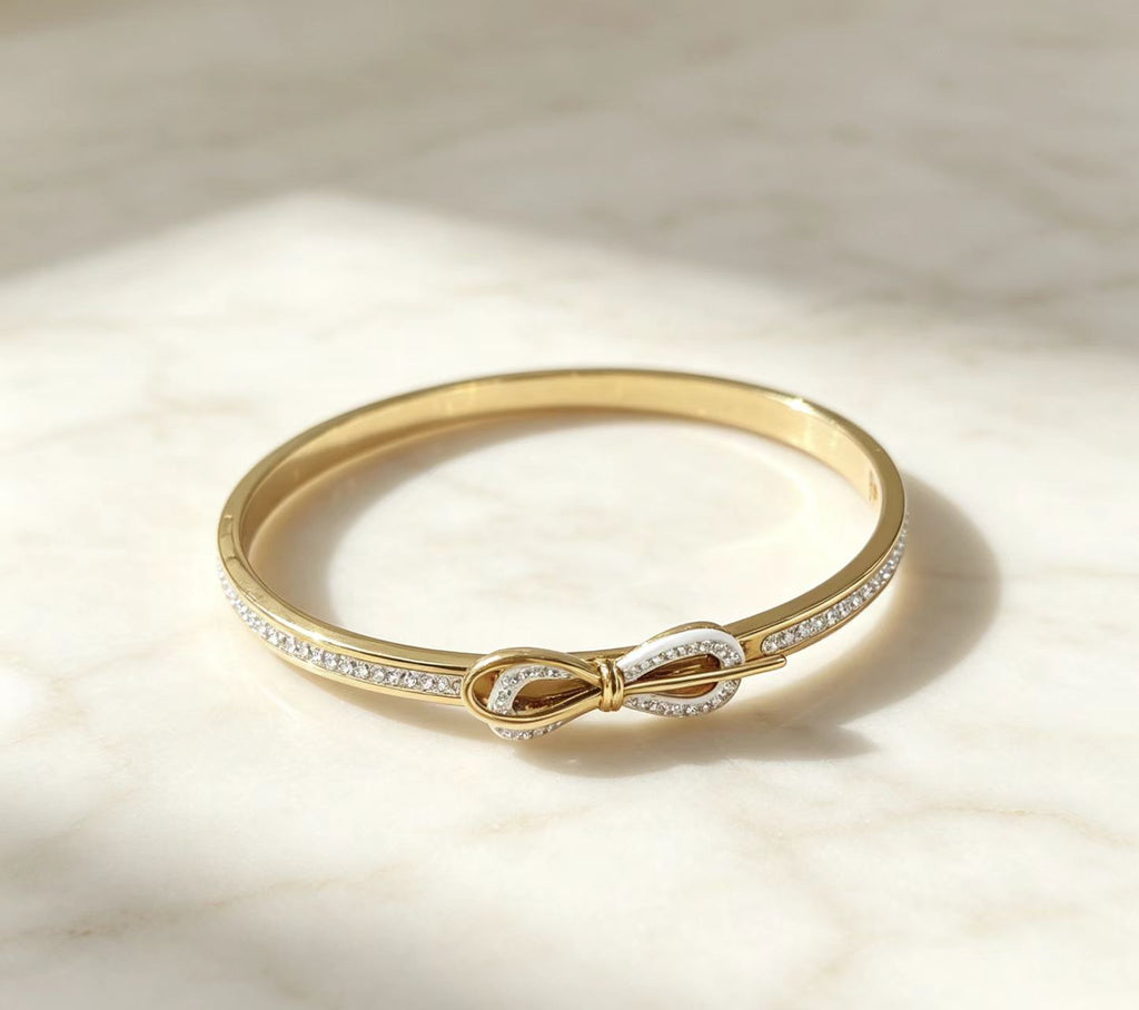 Close-up details of gold electroplated infinity knot bangle cuff