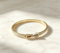 Close-up details of gold electroplated infinity knot bangle cuff