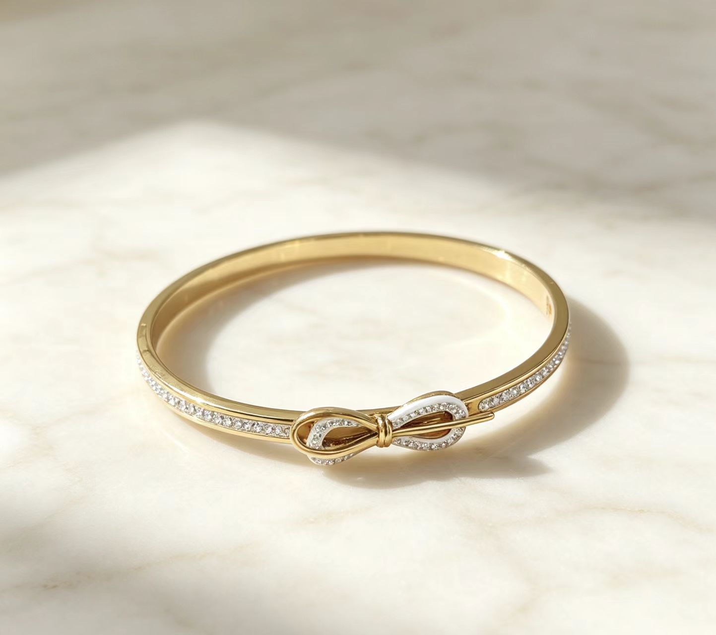 Close-up details of gold electroplated infinity knot bangle cuff