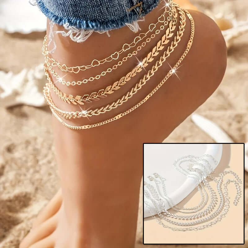 Gold anklets on a person's ankle with a close-up inset on a sandy background
