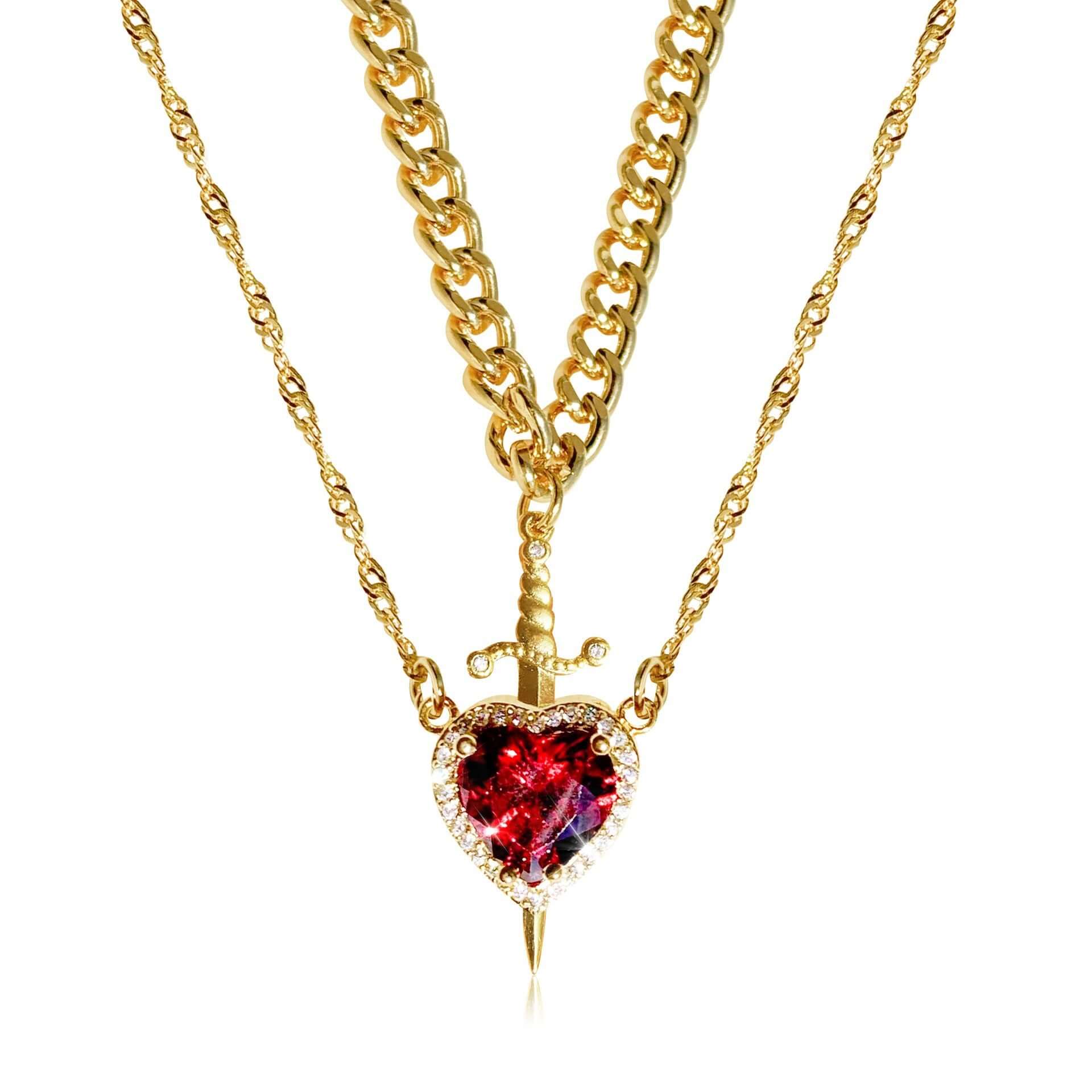 Gold necklace with a heart-shaped red gemstone pendant on a white background