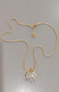 Gold necklace with a pendant on a gray background