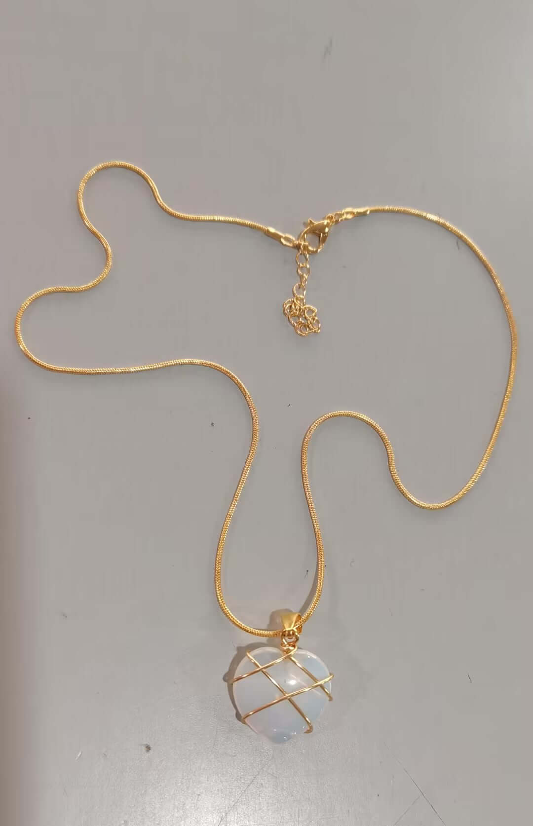 Gold necklace with a pendant on a gray background