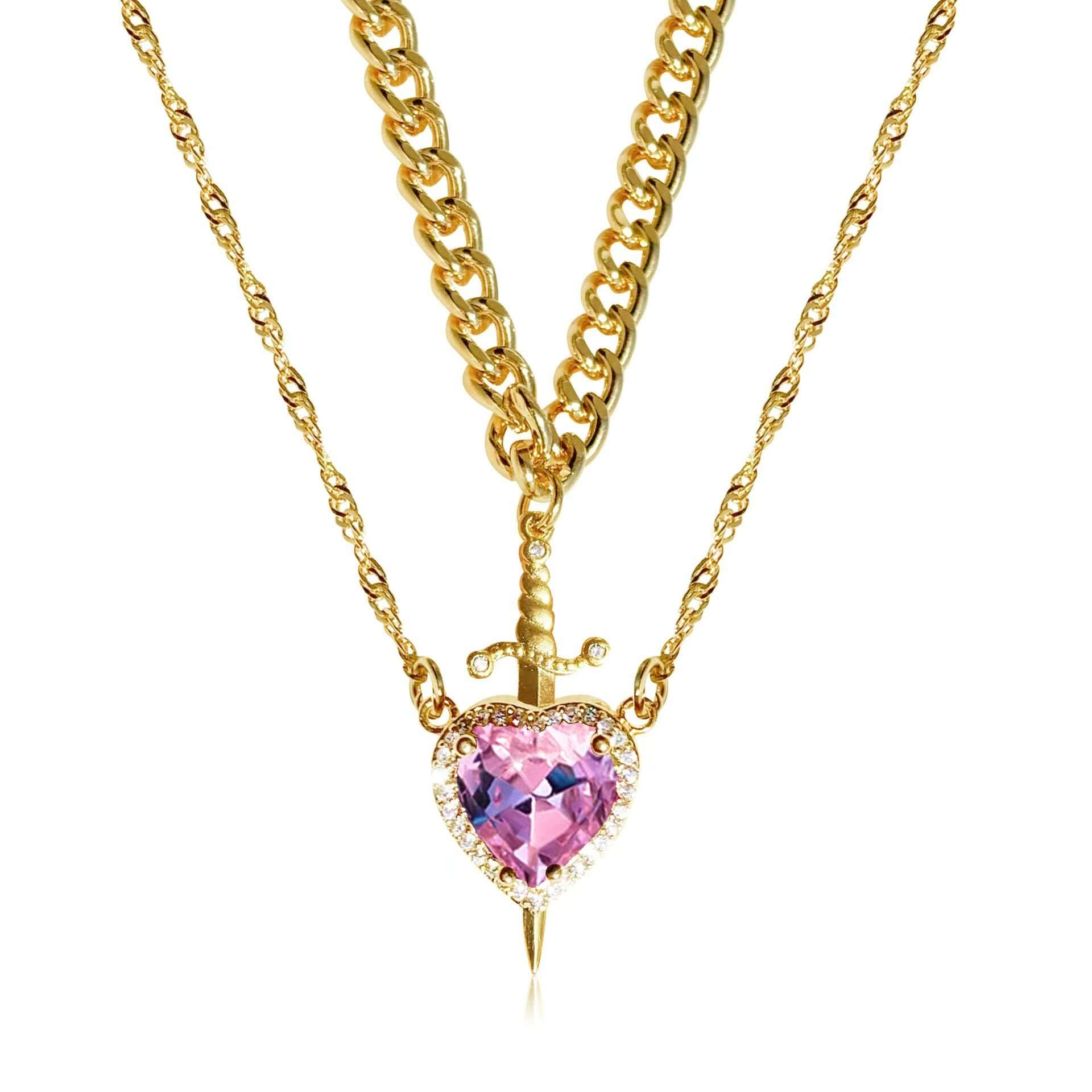 Gold necklace with a pink heart-shaped pendant on a white background