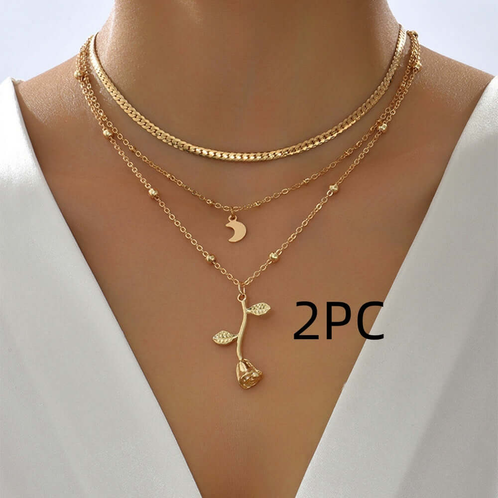 Gold necklaces with a floral pendant on a mannequin against a white background