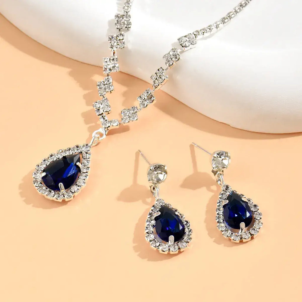 Jewelry set with blue teardrop stones on a peach background