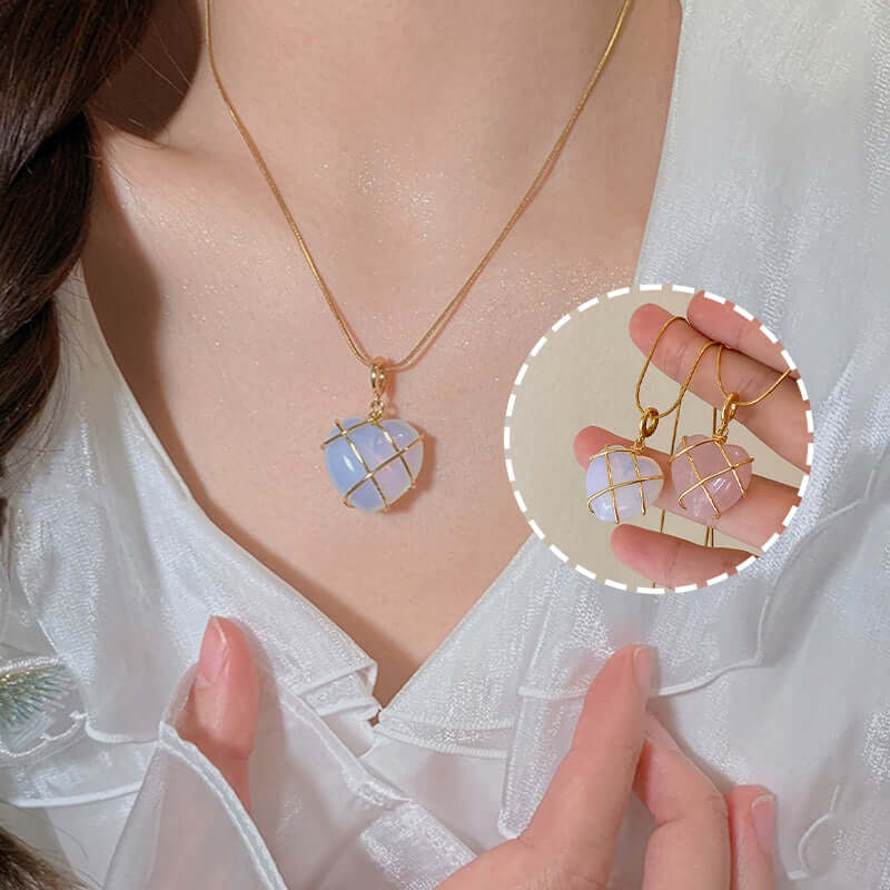 Necklace with a pendant held by a hand, on a white background.