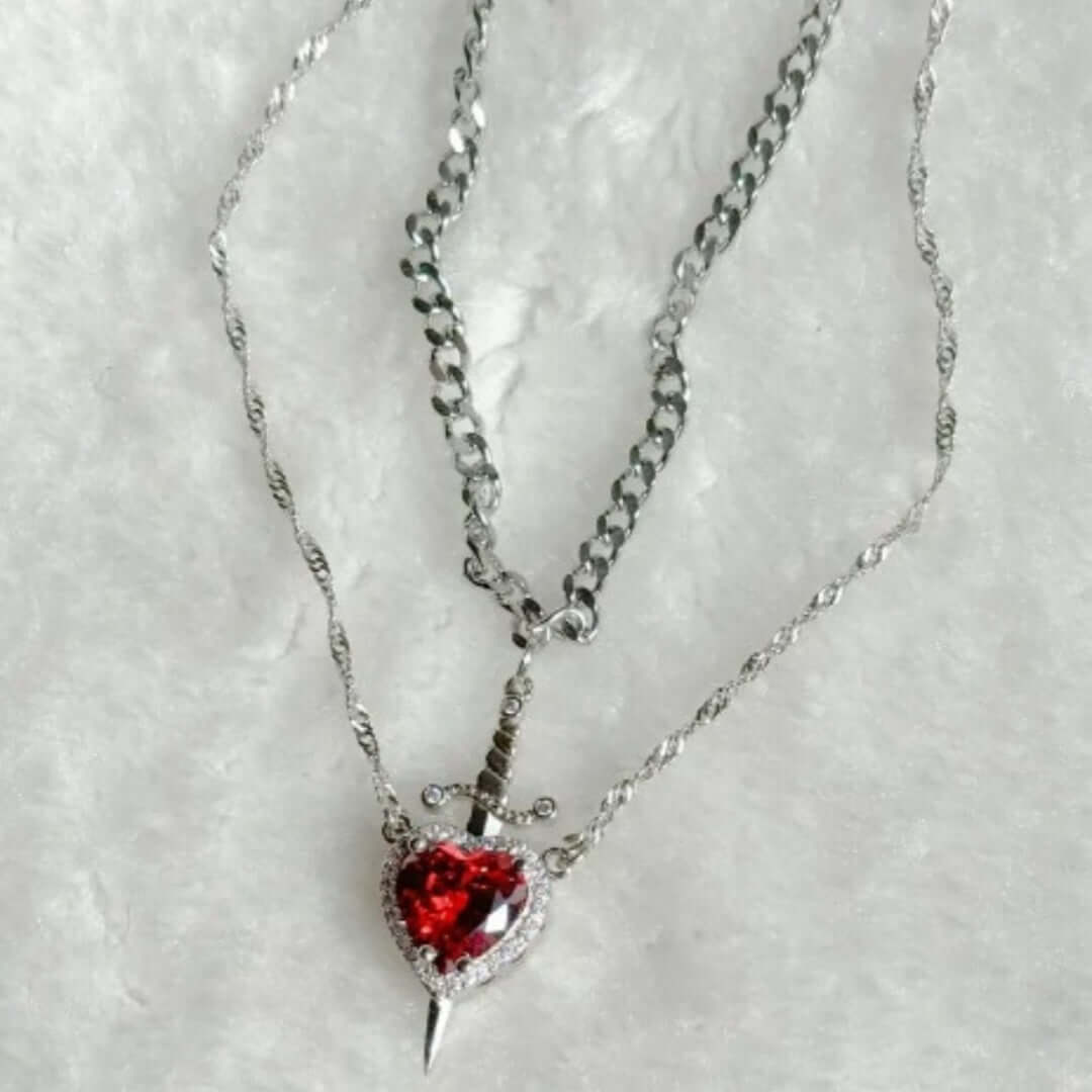 Necklace with a red heart-shaped pendant on a textured white background
