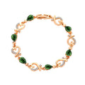Rose gold bracelet with green gemstones on a white background