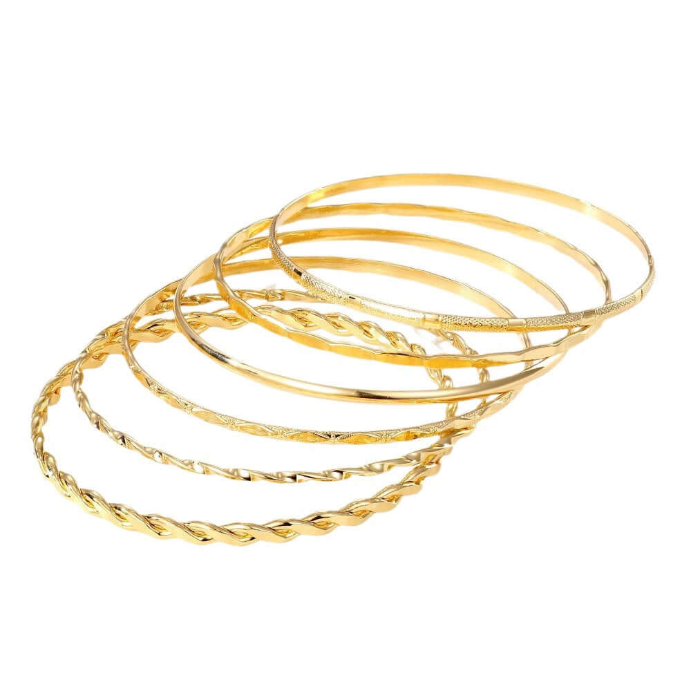 Set of gold bangles on a white background