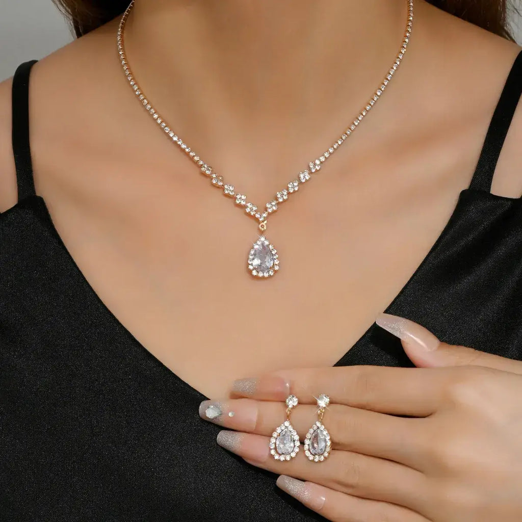Teardrop-shaped jewelry set including necklace, earrings, and ring on a model wearing a black top.