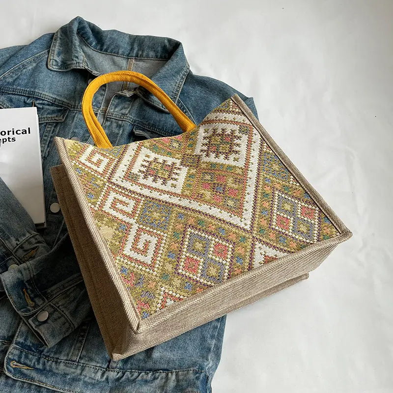 Tote bag with geometric pattern on a denim jacket against a white background