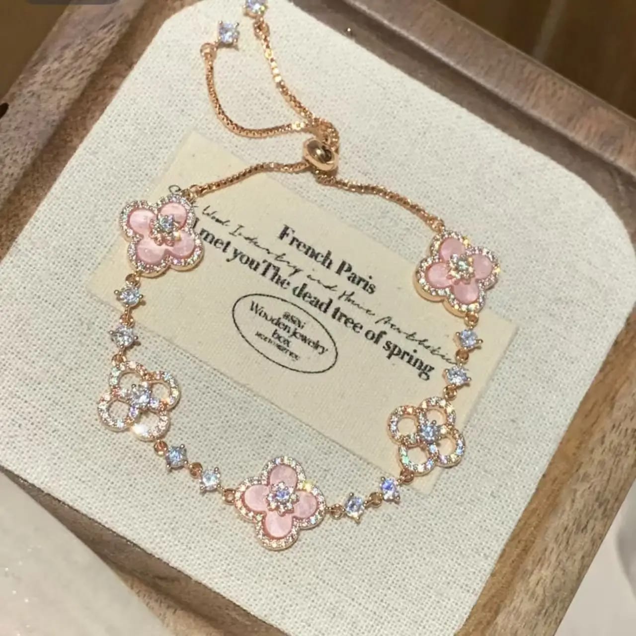 Adjustable rose gold four-leaf clover charm bracelet with pink enamel and sparkling crystals