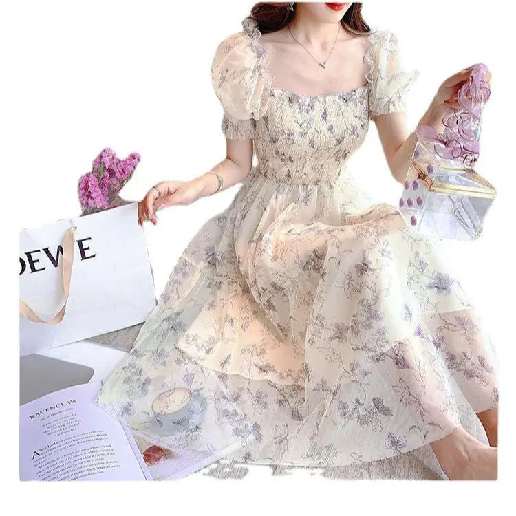 Woman wearing a floral dress holding a pink clutch with a magazine in the background