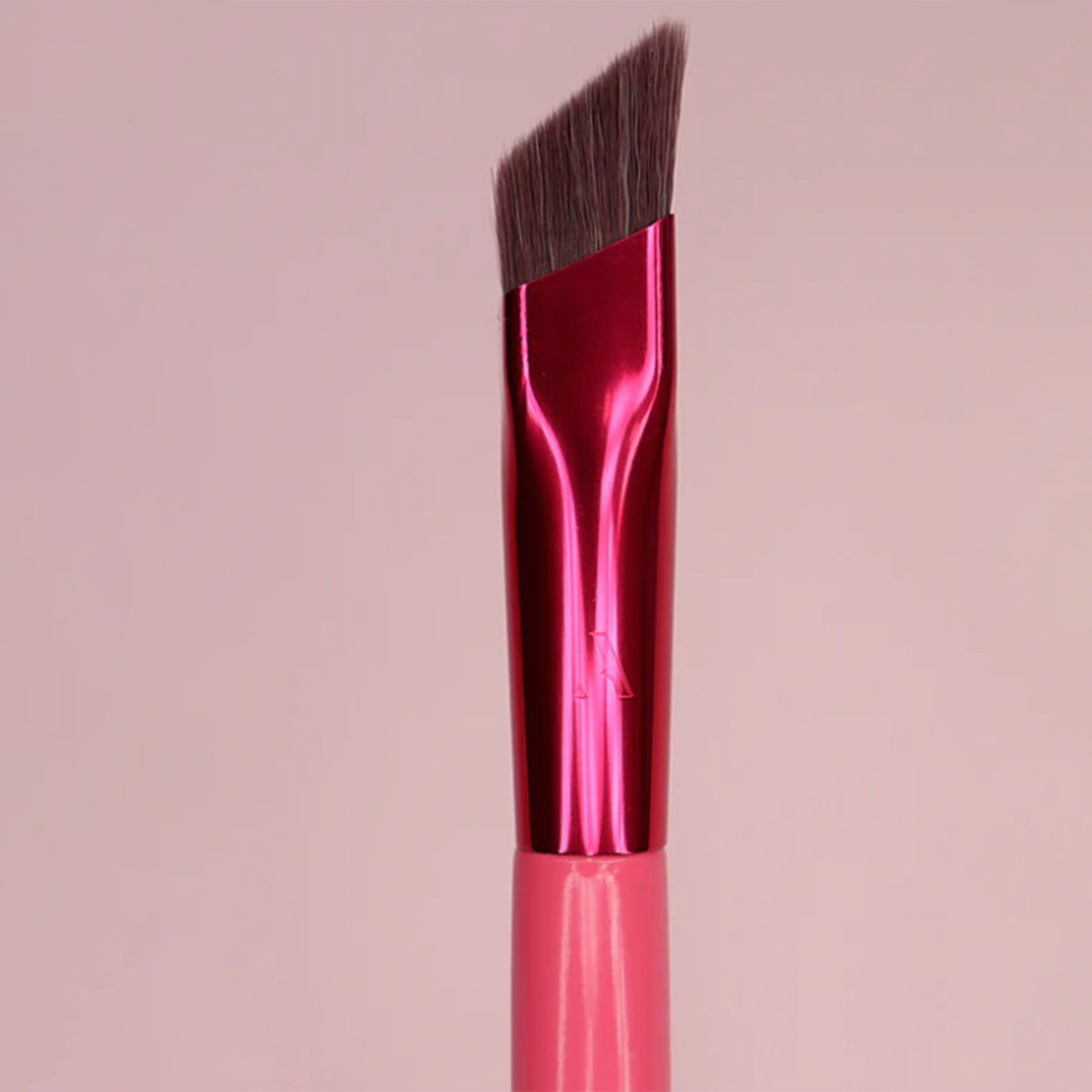 Synthetic firm angled bristles on pink eyebrow brush for clean brow strokes.