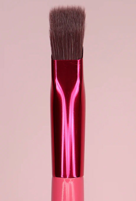 Angled eyebrow brush held upright showing brush head geometry.
