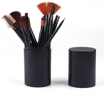  Black cylindrical makeup brush case with the top cap removed sitting beside the brush holder.