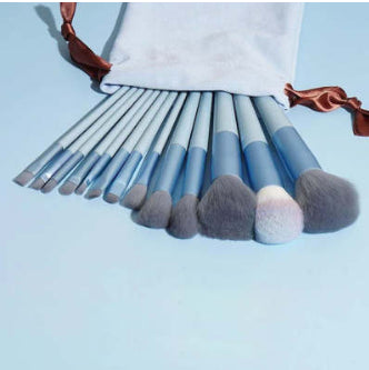  Light blue makeup brushes fanned out displaying handles and bristles.