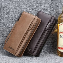 Brown and black leather long clutch wallets resting side by side on a textured surface