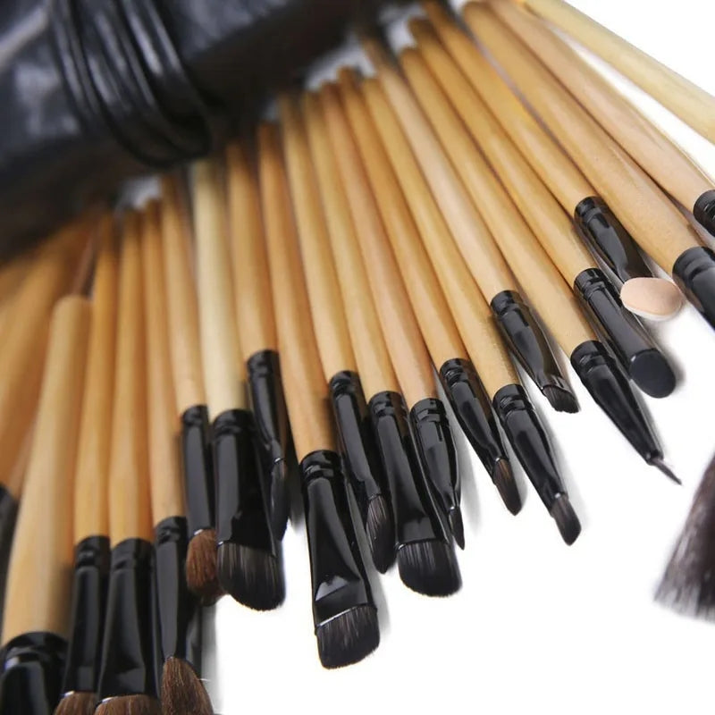Set of makeup brushes with black handles and beige shafts on a white background