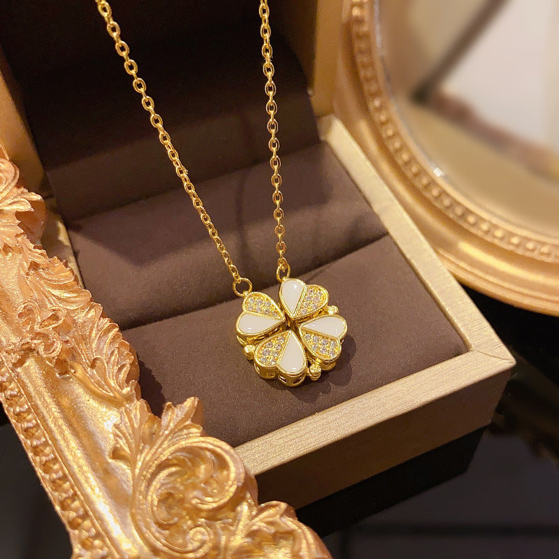  Gold four-leaf clover heart pendant illuminated against a dark velvet background in an ornate frame.