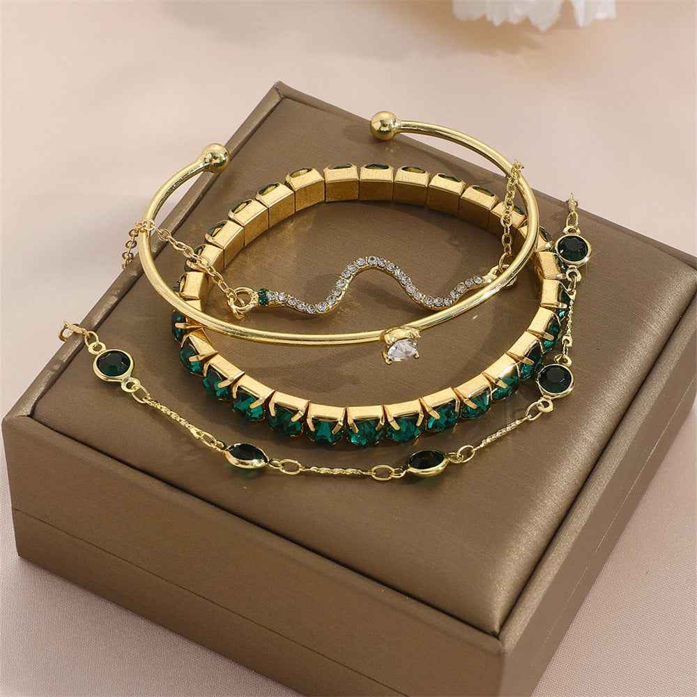  Flat lay of the complete 4-piece gold bracelet set arranged on a light surface showing all chain details and clasp designs.