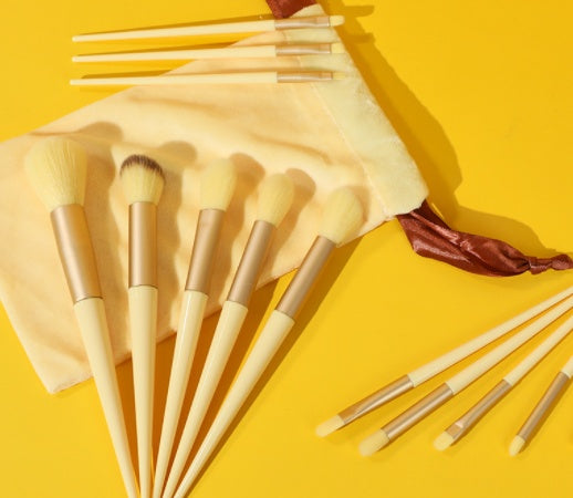 Makeup brush set shown in a warm gold-yellow color option with pouch.