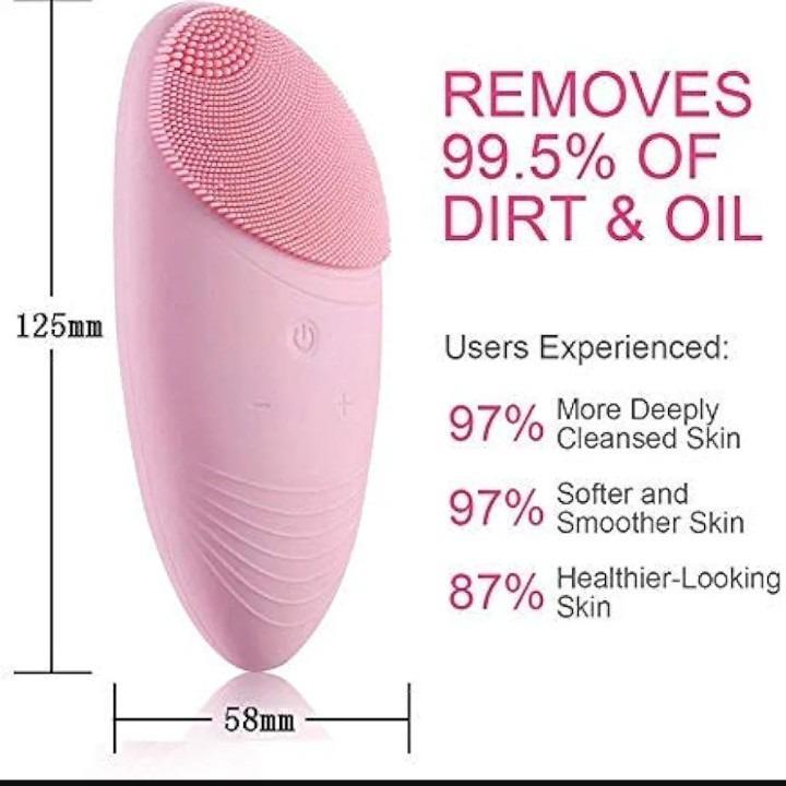 Close-up shot of a hand holding the compact pink silicone face cleanser.