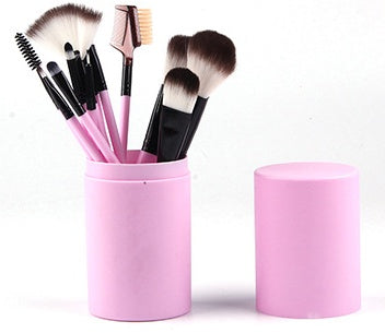  Makeup brushes stored inside a light pink two-piece cylindrical travel case shown next to its open cap.