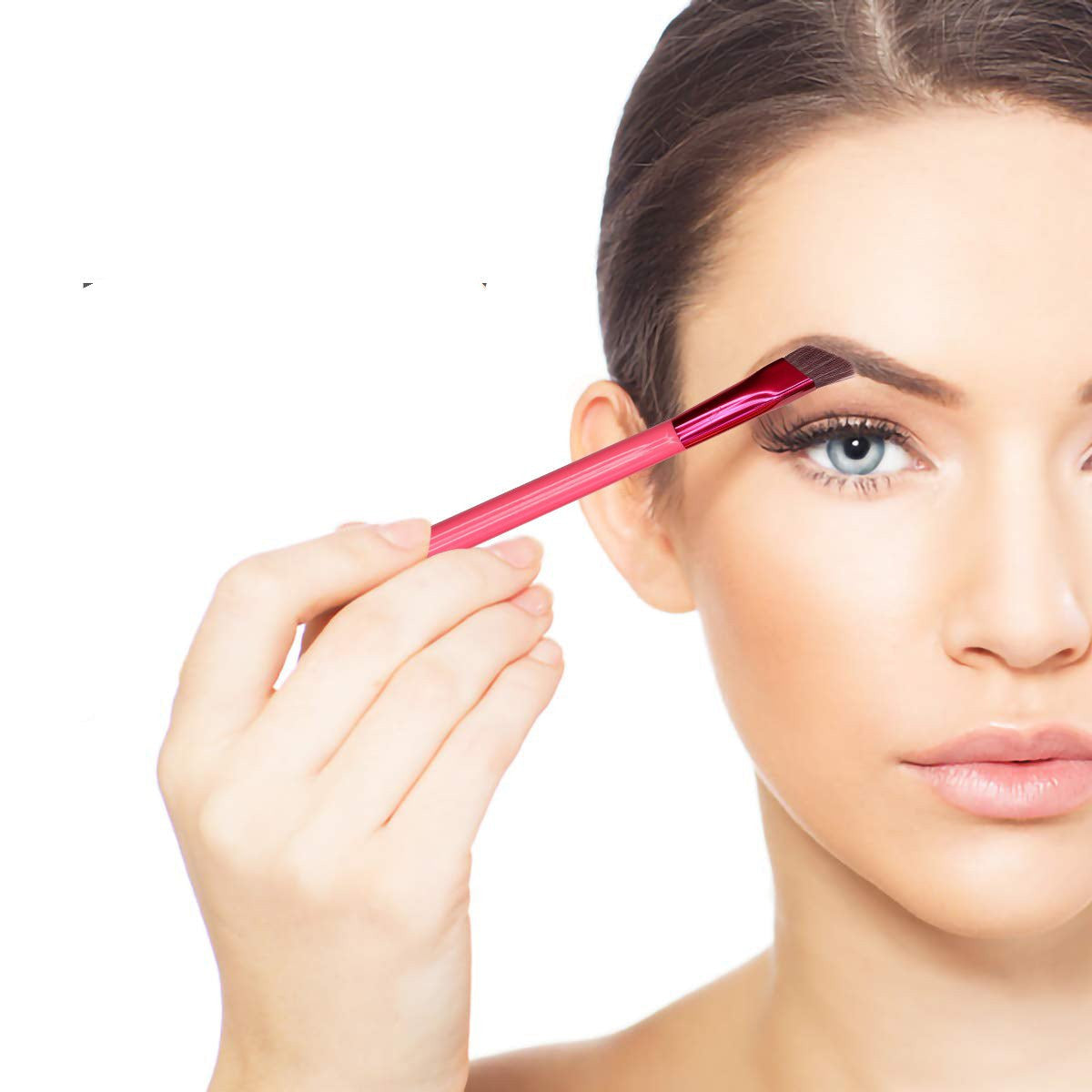 Woman applying black eyebrow pomade using a pink angled brow brush for precise shaping.