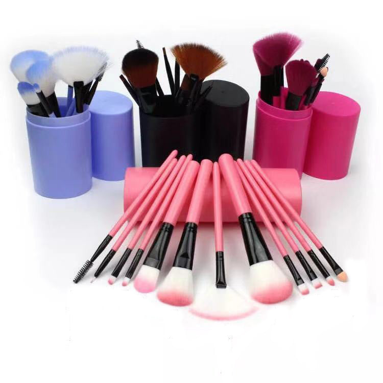 Group shot displaying blue, pink, and black makeup brush sets spread out next to their respective holder cups.