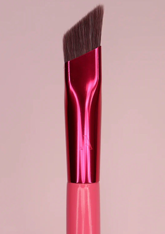 Close-up view of precision angled eyebrow brush with a pink handle.