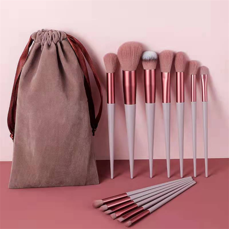 Pink makeup brush set displayed alongside a matching travel pouch.