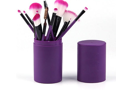  Purple cylindrical storage cup filled with makeup brushes standing next to its removable top lid.
