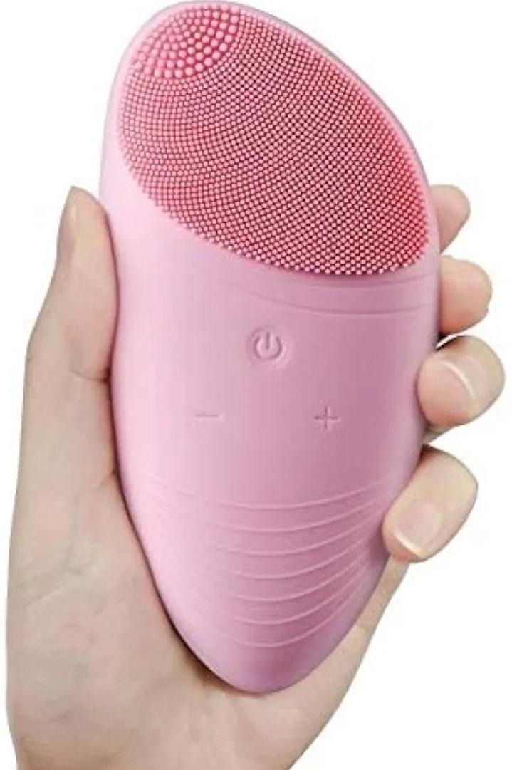 Pink silicone facial cleansing brush with soft bristles on a white background  