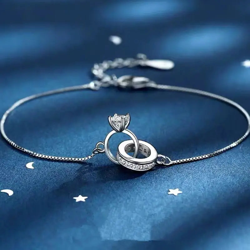  Silver adjustable bolo bracelet featuring sparkling interlocked crystal rings on dark blue silk
