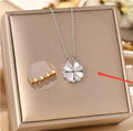  Silver magnetic four-leaf clover necklace resting inside a luxury square metallic gift box.