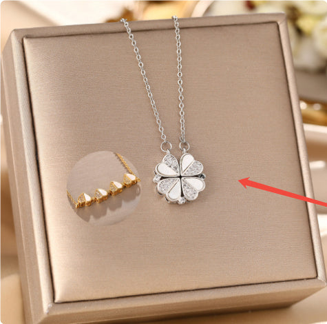  Silver magnetic four-leaf clover necklace resting inside a luxury square metallic gift box.