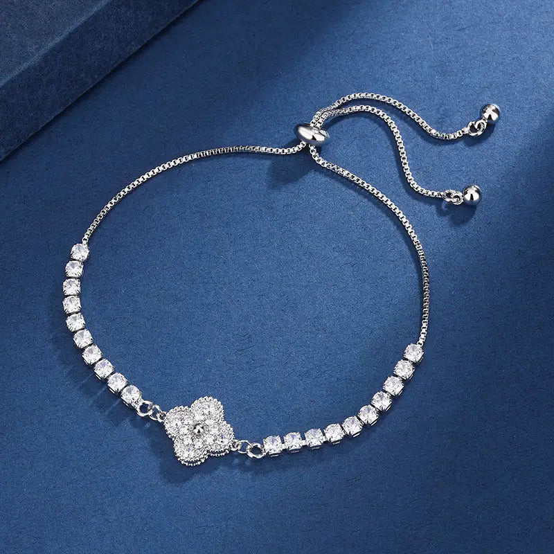 Silver bracelet with floral clasp on a blue background