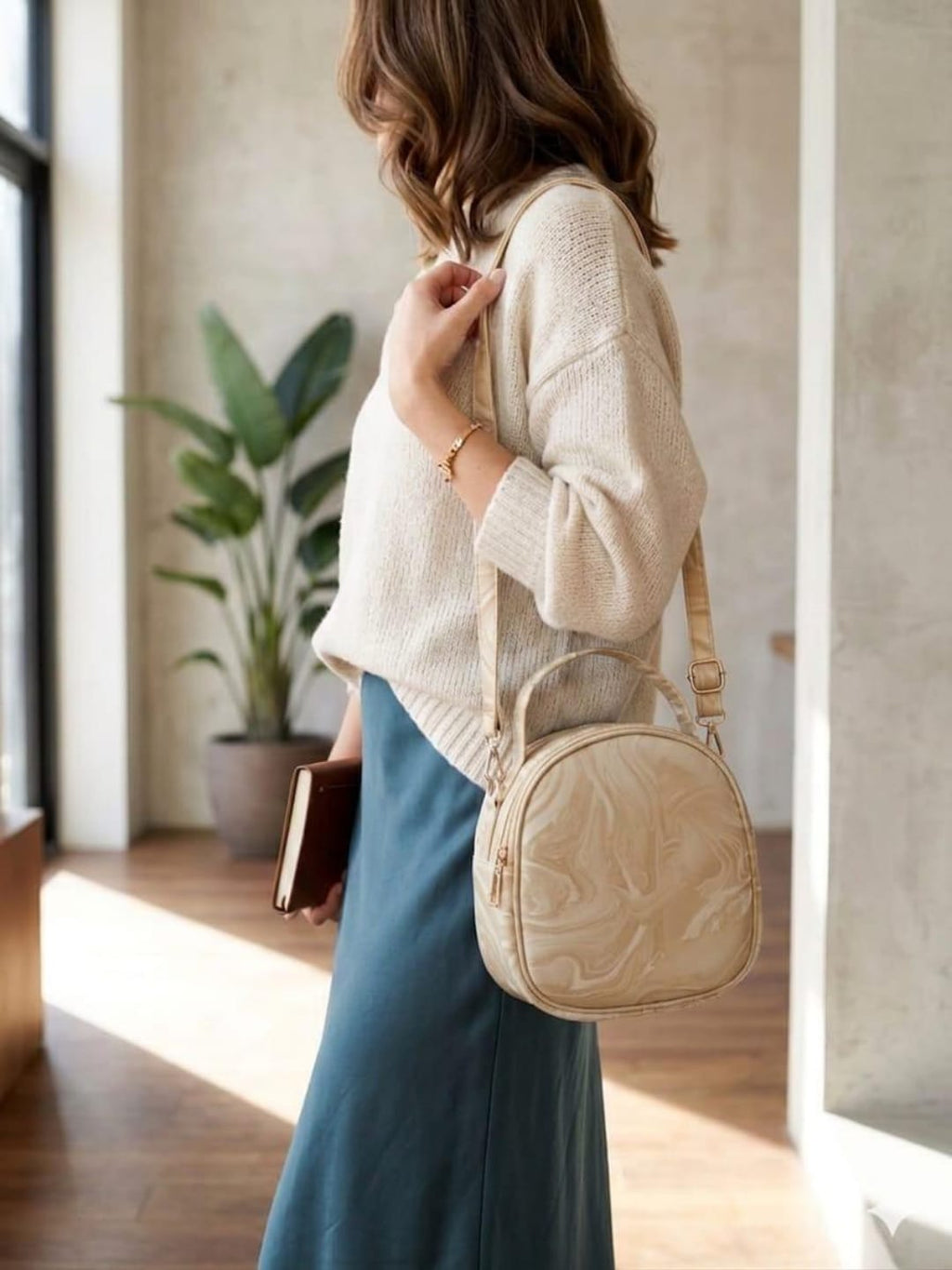 Woman wearing cream beige round crossbody bag