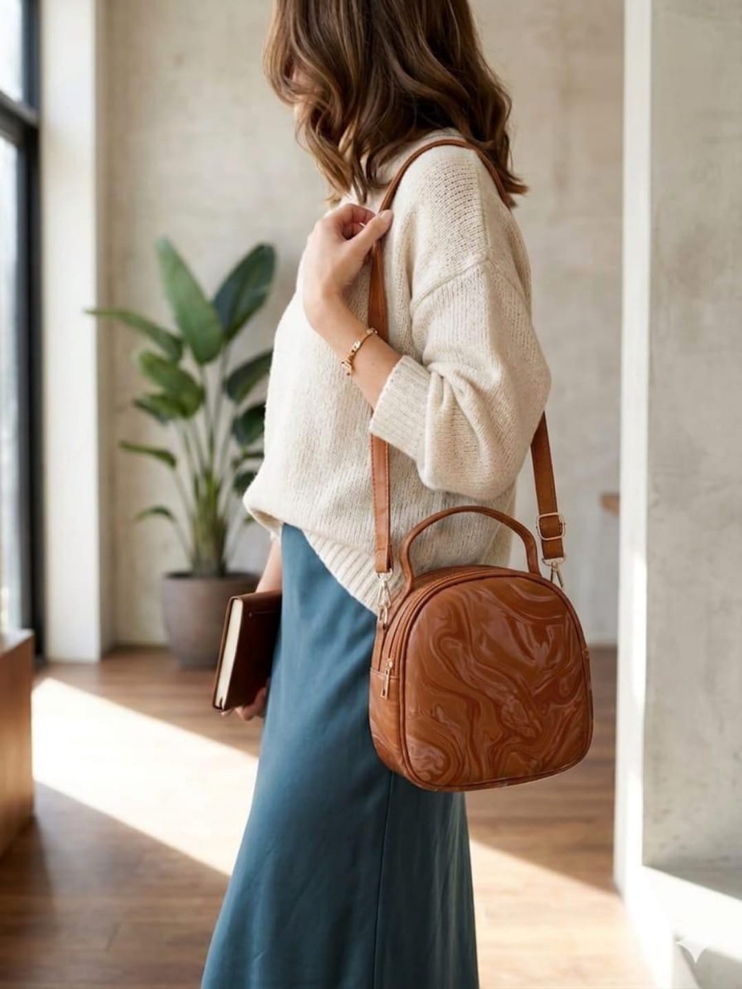 Woman wearing brown round crossbody handbag